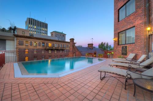 uma piscina num pátio com cadeiras e um edifício em Sir Stamford Circular Quay em Sidney