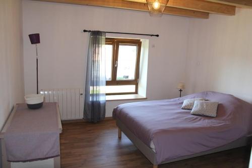 Gîte du Gervaux في Champ-le-Duc: غرفة نوم بها سرير ونافذة