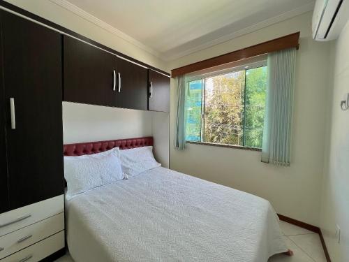 ein kleines Schlafzimmer mit einem Bett und einem Fenster in der Unterkunft Res. Ilha Bela in Bombinhas