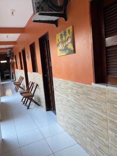 a room with two chairs sitting on the side of a building at Pousada ExtraLar in Fortaleza