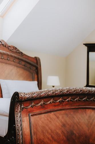 a close up of a wooden bed in a bedroom at Hotel Wileński in Olsztyn