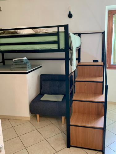 a room with two bunk beds and a chair at Old Porlezza Apartment in Porlezza
