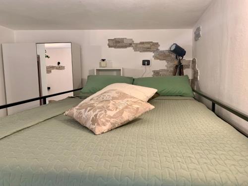 a bedroom with a large bed with green sheets at Old Porlezza Apartment in Porlezza