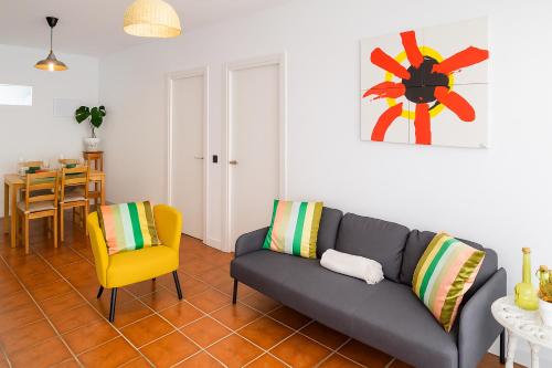 a living room with a couch and a yellow chair at Casa Segunda in Tías