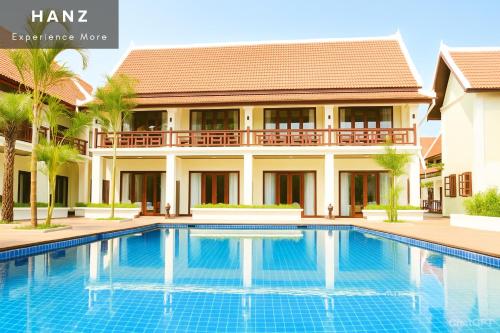 a villa with a swimming pool in front of a house at Sunrise Hotel Luang Prabang Mekong river in Luang Prabang