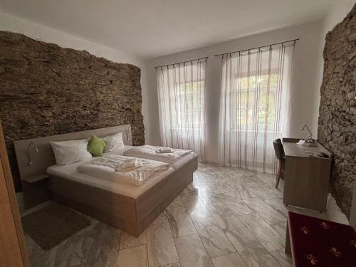 a bedroom with a bed and a desk and a window at Hotel Sächsischer Hof in Scheibenberg in Scheibenberg
