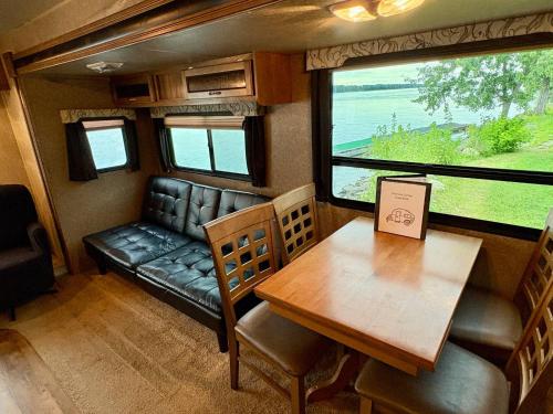 sala de estar con mesa, sofá, mesa y sillas en Riverfront Camper, en Bellevue