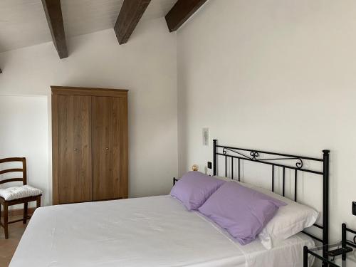 a bedroom with a bed with a purple pillow at Casale Col di Massa Residenza di campagna in Costacciaro
