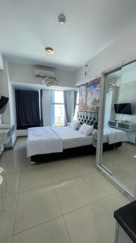 スラバヤにあるLuxury Apartemen Anderson Benson PTC By Staycationの広いベッドルーム(ベッド2台、窓付)