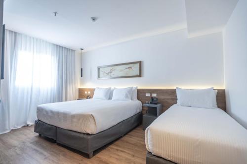 une chambre d'hôtel avec deux lits et une fenêtre dans l'établissement Dazzler by Wyndham Salta, à Salta