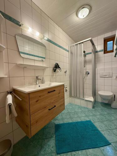 a bathroom with a sink and a shower and a toilet at Ferienwohnung Seethaler - Gartenblick in Thiersee