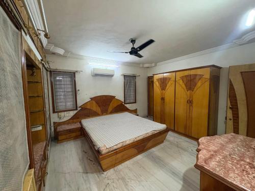 a bedroom with two beds and a ceiling fan at Shree Homes ENTIRE BUNGLOW in Surat
