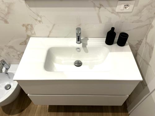 a white sink in a bathroom with a toilet at Casa Rockfeller in Alghero