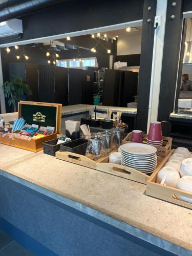 a restaurant counter with plates and dishes on it at 森の中で仲間や家族とゆっくり過ごせる温泉付コテージ 会員制別荘地で広大なプライベート空間 ペット可 那須高原りんどうハウス in Nasu