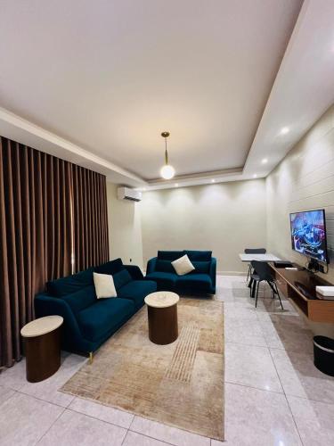 a living room with a blue couch and a table at شقق فاتوران فرع أبا ذر in Al Madinah