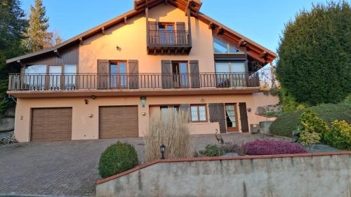 a house with a balcony and a fence at La Chambre d'hôte in Wisembach