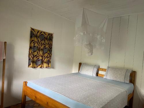 a bedroom with a bed and a picture on the wall at Casas Salomão in Santo António