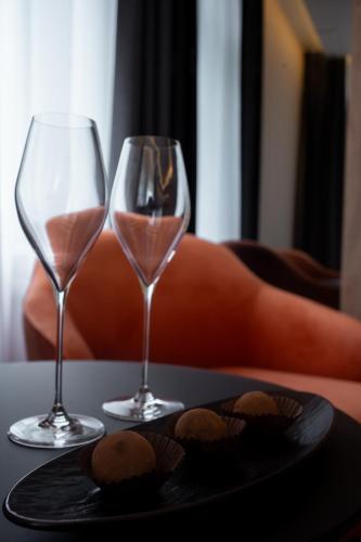 two wine glasses and a plate of cookies on a table at Rinvoks boutique hotel in Kremenchuk