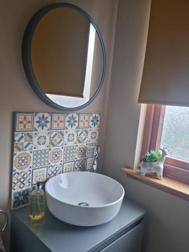 a bathroom with a large sink and a mirror at Village view apartment in Auldearn