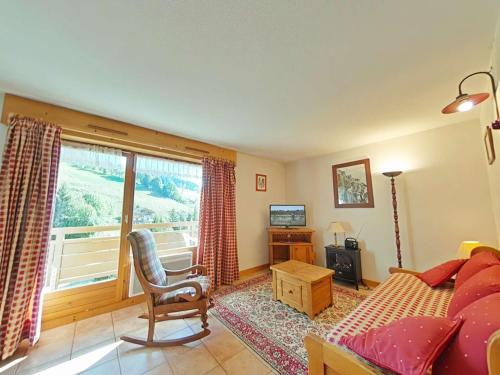 a bedroom with a bed and a chair and a window at Appt 3 pièces, 6 couchages, proche commerces et pistes, parking inclus, animaux admis - FR-1-241-177 in Le Grand-Bornand