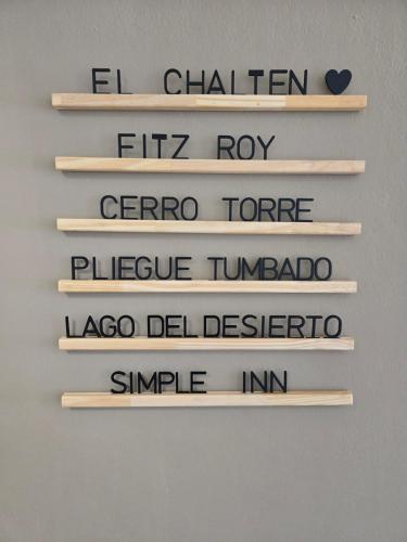 a set of wooden signs with the words el chicken filipino fipop ro at SIMPLE Inn in El Chalten