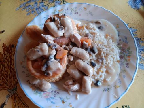 a plate of food with chicken and rice on a table at Au charmes des cigognes in Sarralbe
