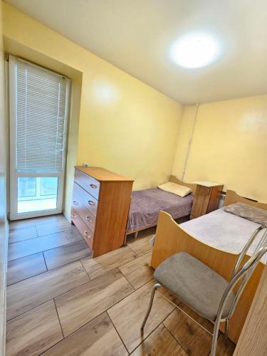 a room with two beds and a dresser and a window at 4х кімнатна квартира in Cherkasy