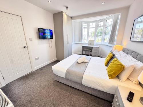a bedroom with a large bed and a desk with a laptop at OX London Heathrow stay - 1 BUS to HEATHROW in New Bedfont