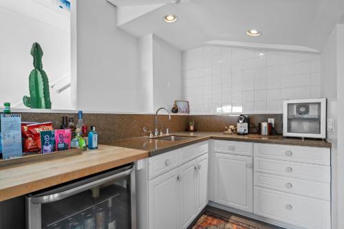 a white kitchen with a sink and a microwave at Hotel Erwin Venice Beach in Los Angeles