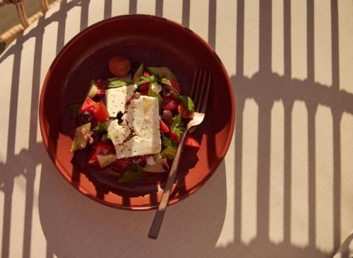 a bowl of salad with a fork on a table at Hotel Erwin Venice Beach in Los Angeles