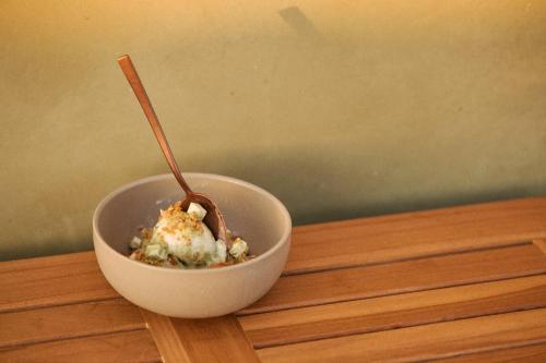 a bowl of food with a spoon in it on a table at Hotel Erwin Venice Beach in Los Angeles