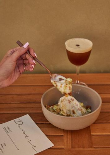 a person eating a bowl of food with a drink at Hotel Erwin Venice Beach in Los Angeles
