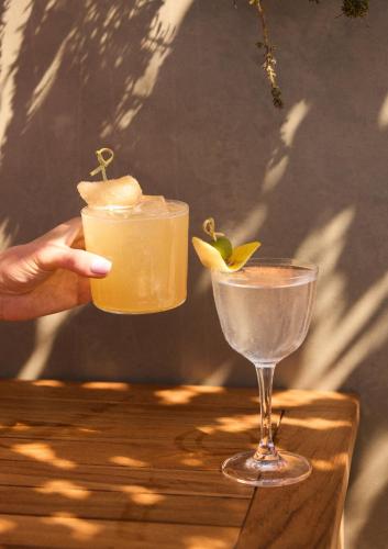 a person holding a drink next to a glass at Hotel Erwin Venice Beach in Los Angeles