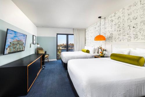 a hotel room with two beds and a desk at Hotel Erwin Venice Beach in Los Angeles