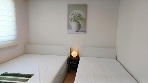 two beds in a room with a picture on the wall at 무료주차 수원역차량 5분 행궁동차량7분 in Suwŏn-yŏk