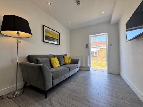 a living room with a couch and a lamp at OX London Heathrow stay - 1 BUS to HEATHROW in New Bedfont