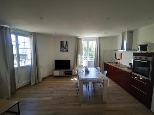 ein Wohnzimmer mit Tisch und Küche in der Unterkunft Appartement au bord de la Vienne in Châtellerault