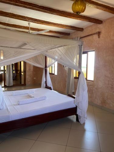 a bedroom with a large bed with a canopy at Watamu Villa in Watamu