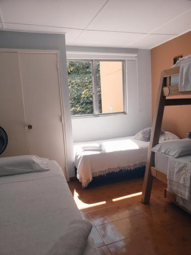 Un dormitorio con dos literas y una ventana. en Casa hotel la 33, en Medellín