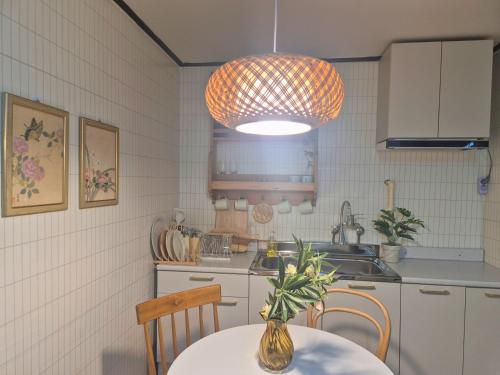 a kitchen with a table and a pendant light at 소소가 in Samgong
