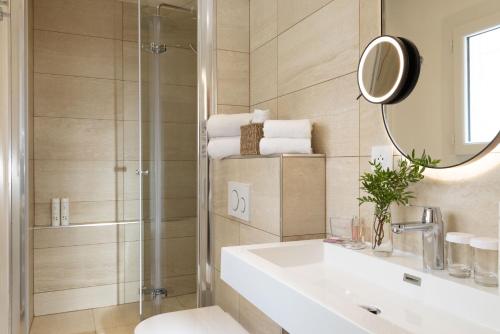 a bathroom with a sink and a shower and a mirror at Hotel Des Deux Continents in Paris