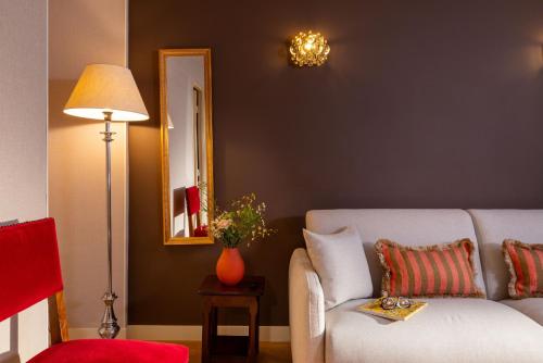 a living room with a couch and a mirror at Hotel Des Deux Continents in Paris