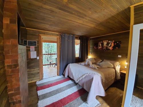 a bedroom with a bed and a wooden ceiling at Pousada Chales da Mantiqueira - Campos do Jordão in Campos do Jordão