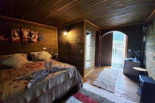 a bedroom with a bed with a person laying on it at Pousada Chales da Mantiqueira - Campos do Jordão in Campos do Jordão