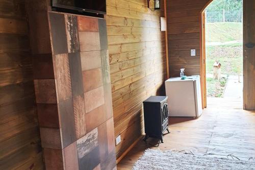 a corner of a room with a wooden wall with a television at Pousada Chales da Mantiqueira - Campos do Jordão in Campos do Jordão