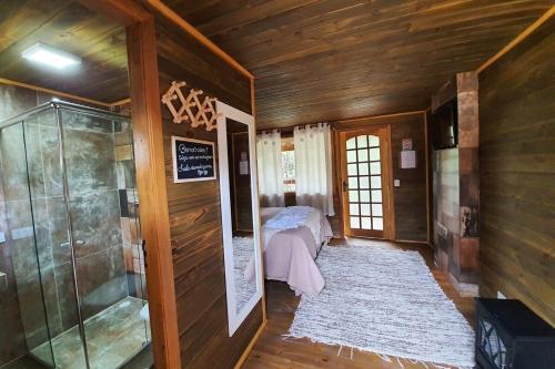 a small room with a bed and a walk in shower at Pousada Chales da Mantiqueira - Campos do Jordão in Campos do Jordão