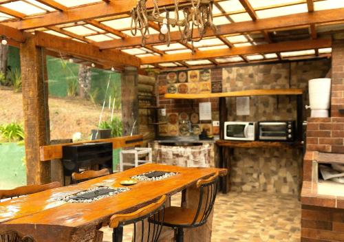 an outdoor kitchen with a wooden table and a counter at Pousada Chales da Mantiqueira - Campos do Jordão in Campos do Jordão