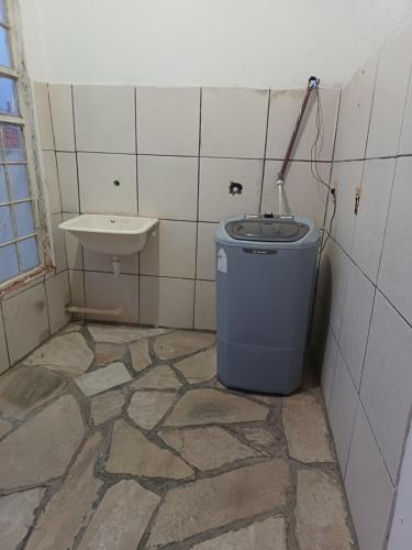 a bathroom with a trash can and a sink at Hostel Goiabeiras in Cuiabá