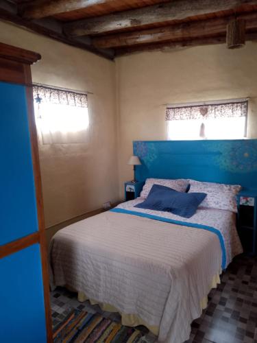 a blue bedroom with a bed with a blue headboard at Cabaña Maria y Oscar in Villa Giardino