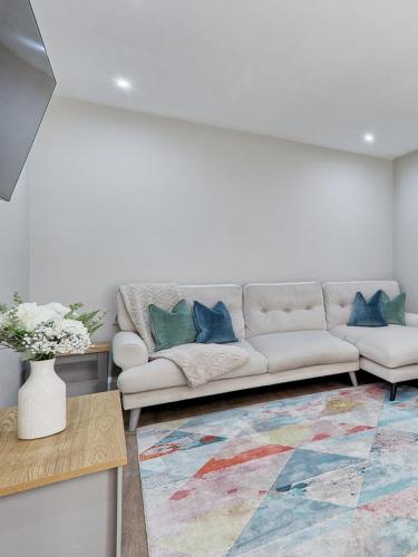 a living room with a couch and a rug at Large House Erith DA8 - 6 BDR - Sleeps up to 12 Guest - Parking - Garden - WiFi- Contractors - Families - Groups - Discounts Available for Long Term Bookings! in Erith